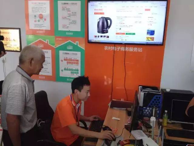 (老大爷在农村淘宝服务站选购热水壶)